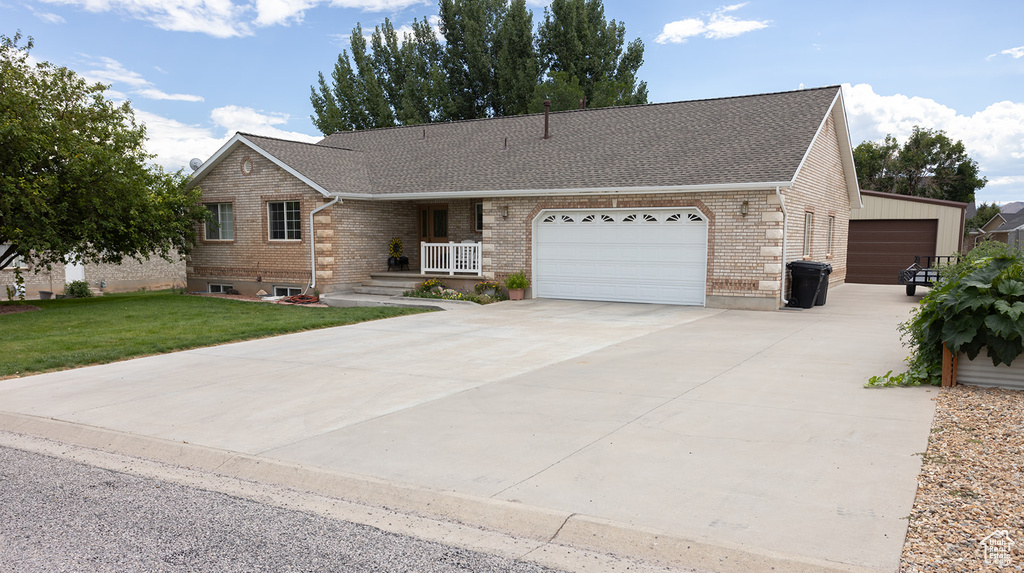 Ranch-style house with a garage and a front lawn