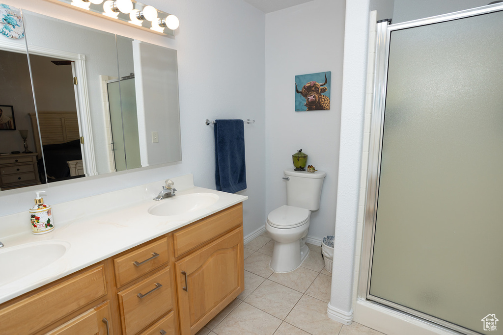 Bathroom featuring tile patterned flooring, vanity, toilet, and an enclosed shower