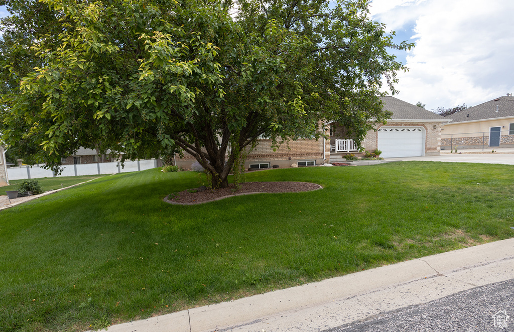 View of front of property featuring a garage and a front yard