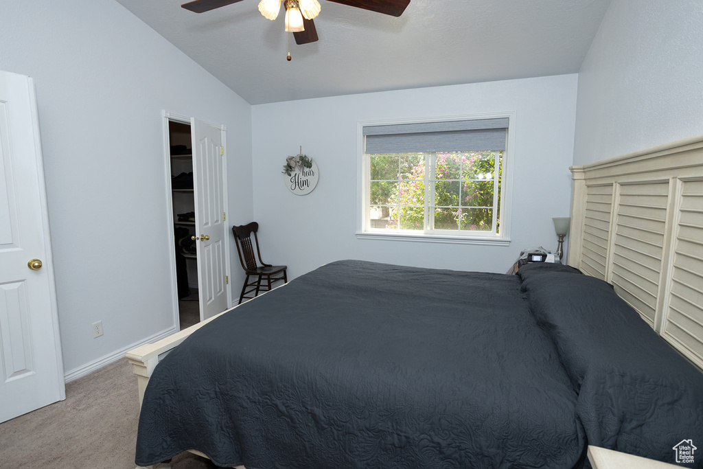 Bedroom featuring vaulted ceiling, ceiling fan, and carpet