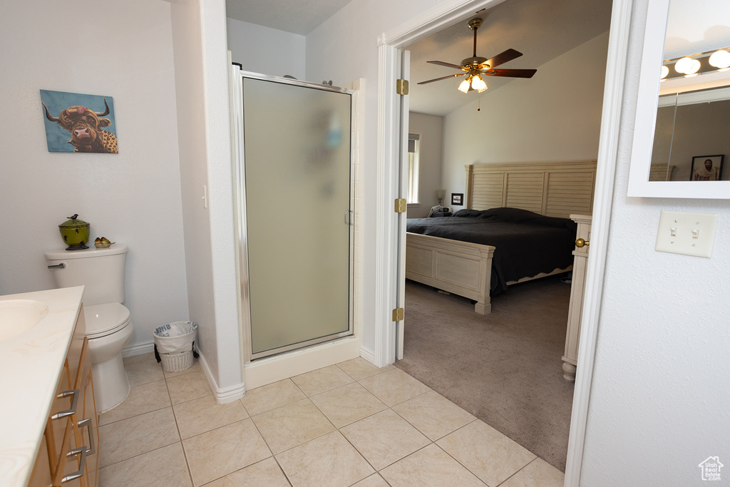 Bathroom featuring a shower with door, toilet, lofted ceiling, ceiling fan, and vanity