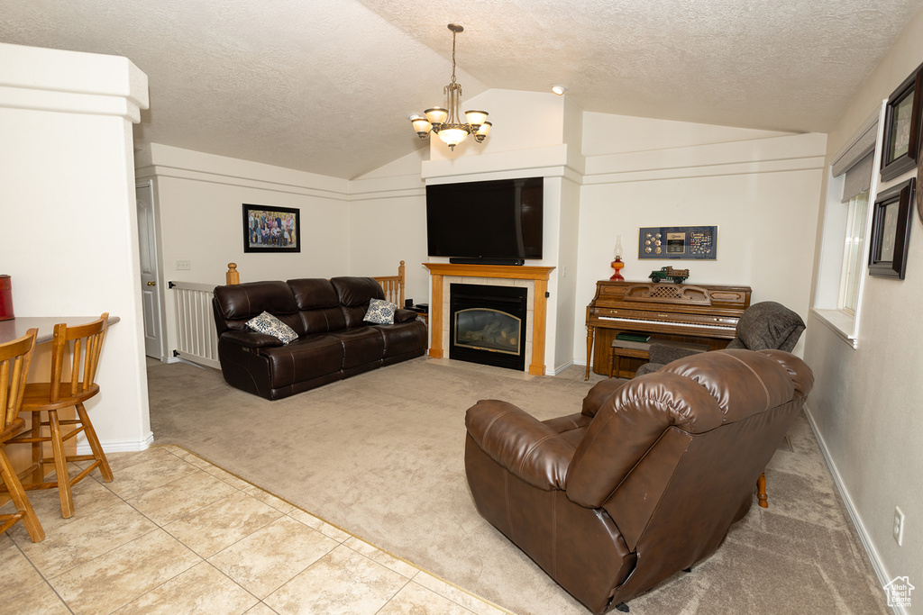 Carpeted living room with a chandelier, a textured ceiling, and vaulted ceiling