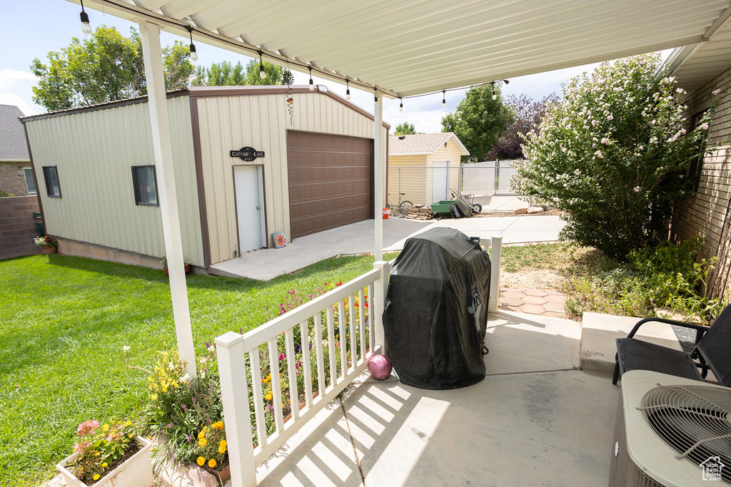 View of patio with a garage and an outbuilding