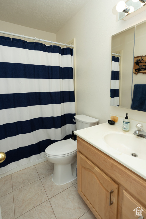 Bathroom with toilet, tile patterned floors, vanity, a textured ceiling, and a shower with curtain