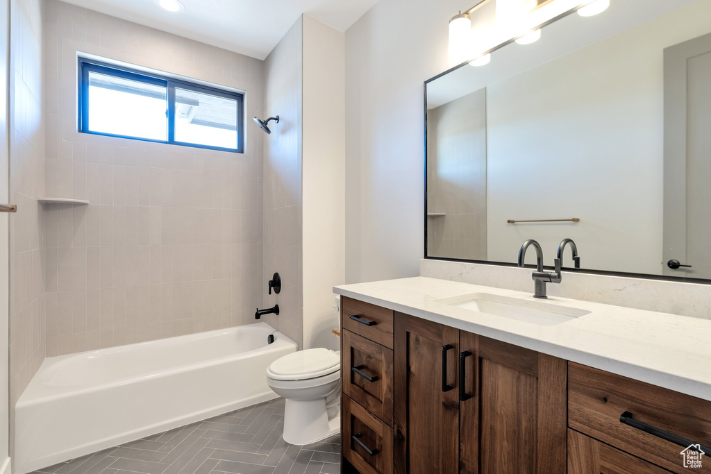 Full bathroom with tiled shower / bath, toilet, and vanity