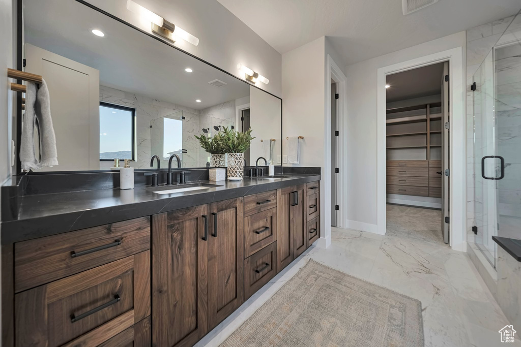 Bathroom featuring a shower with door and vanity