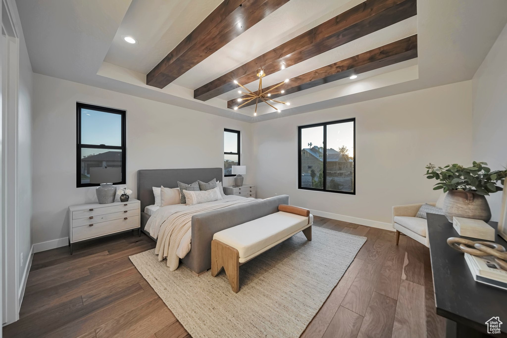 Bedroom featuring dark wood-type flooring, beamed ceiling, and an inviting chandelier