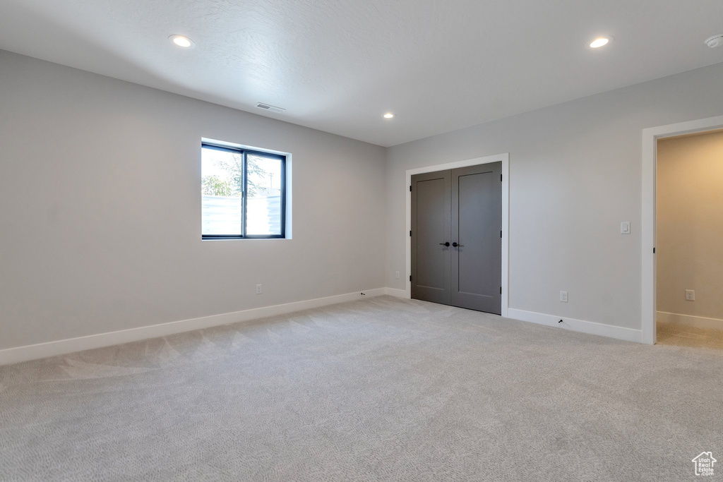 Unfurnished bedroom with light colored carpet