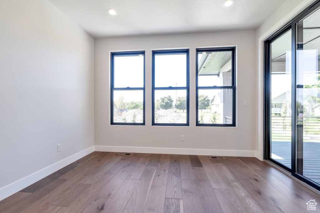 Spare room with a healthy amount of sunlight and hardwood / wood-style flooring