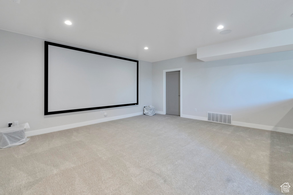 Home theater room featuring light colored carpet