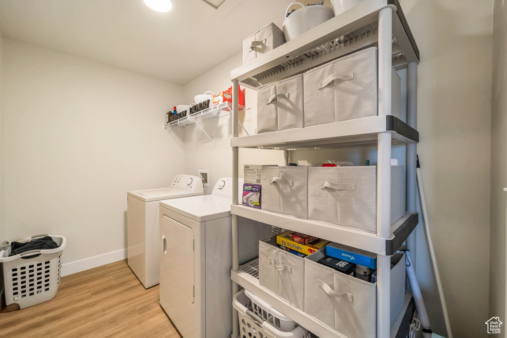 Washroom featuring washing machine and clothes dryer and light wood-type flooring