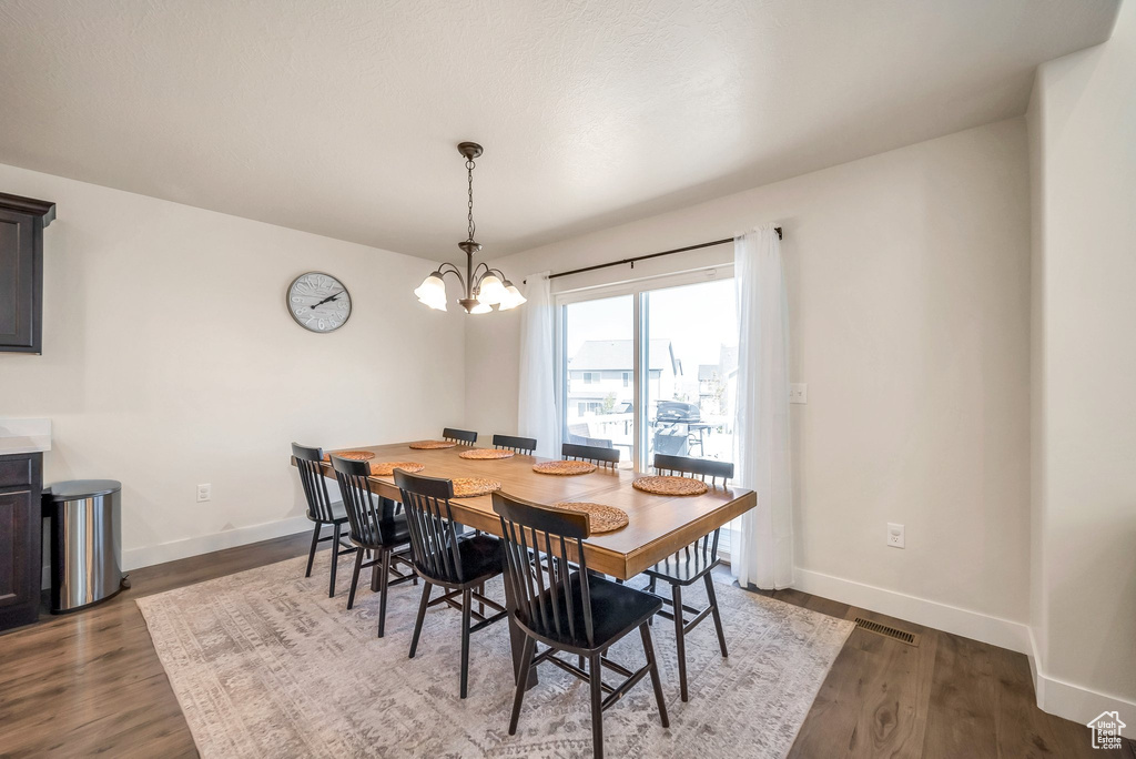 Dining room with hardwood / wood-style flooring and a notable chandelier