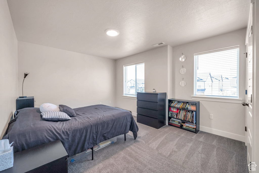 Bedroom with a textured ceiling and carpet flooring