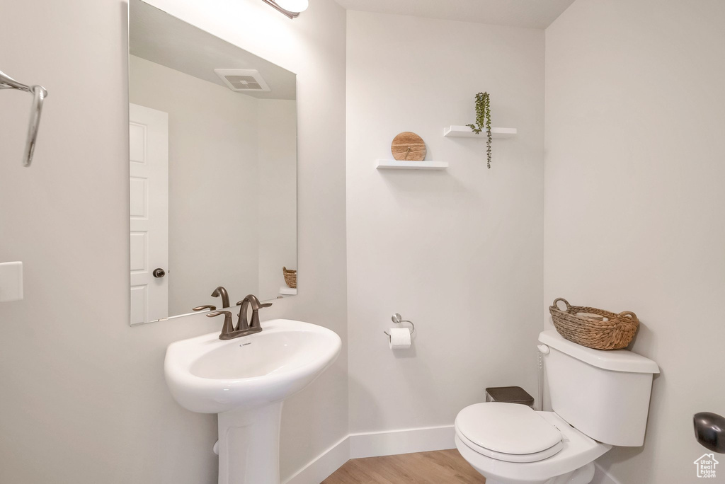 Bathroom featuring wood-type flooring and toilet