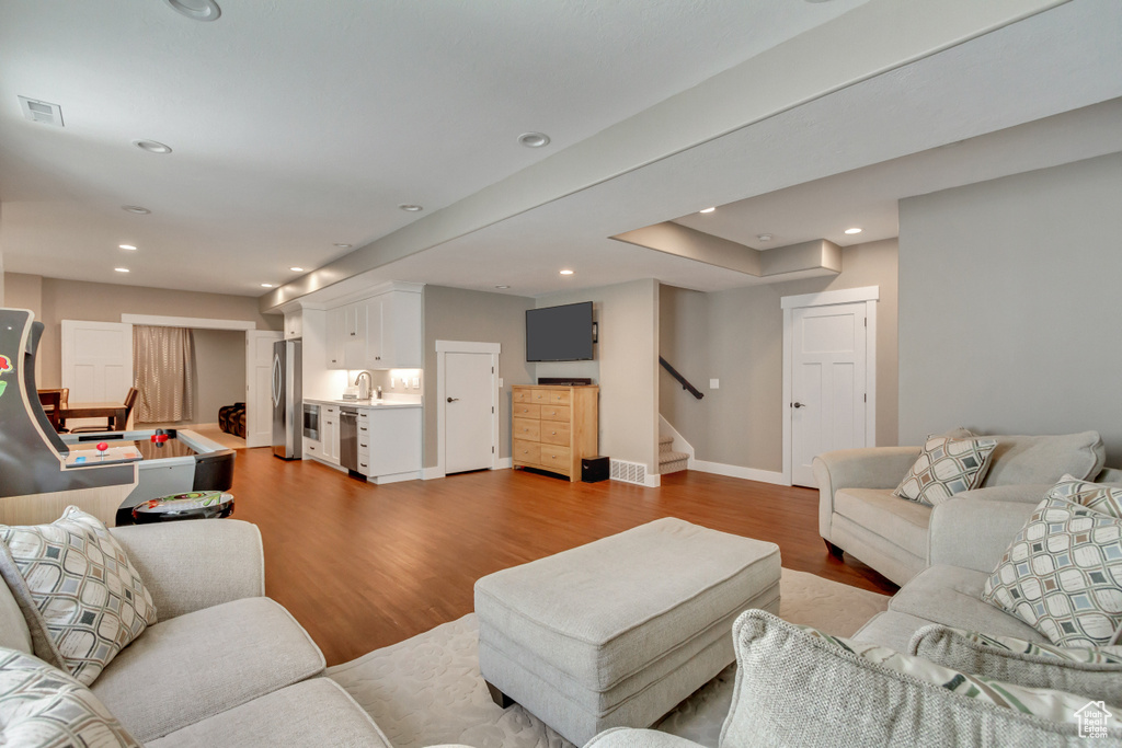 Living room featuring sink, wine cooler, and light wood-type flooring