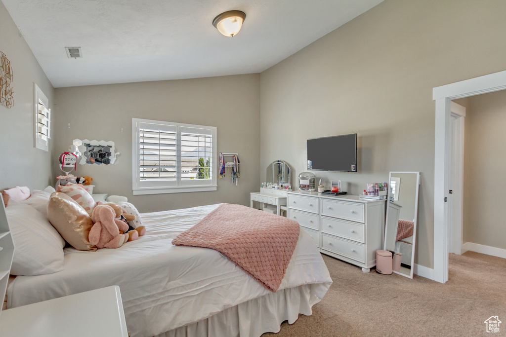 Bedroom featuring lofted ceiling and light carpet