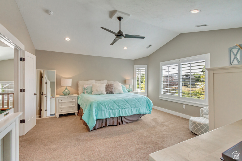 Bedroom with lofted ceiling, ceiling fan, and light carpet