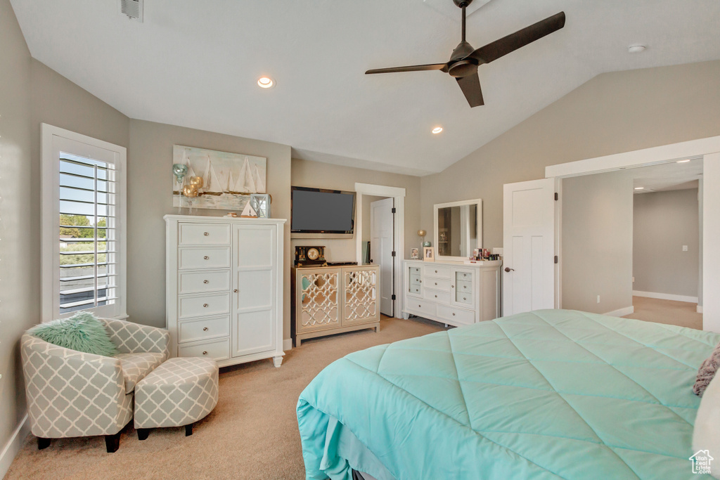 Carpeted bedroom with lofted ceiling and ceiling fan