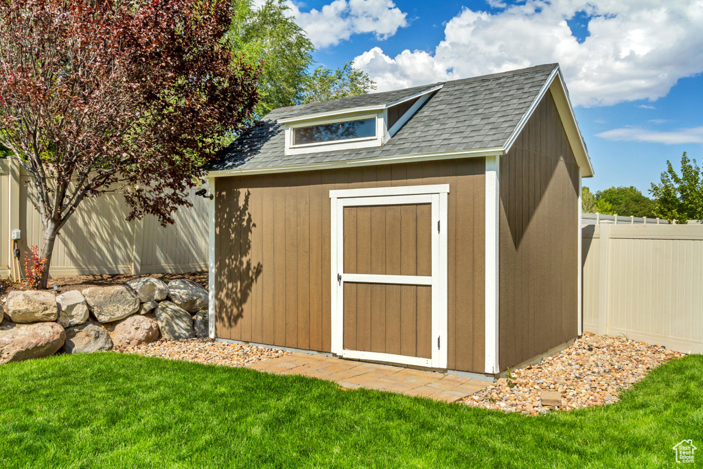 View of outbuilding featuring a lawn