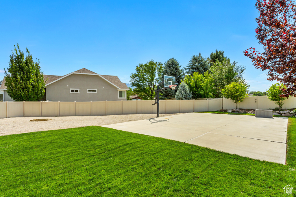 View of yard featuring basketball court and a patio area