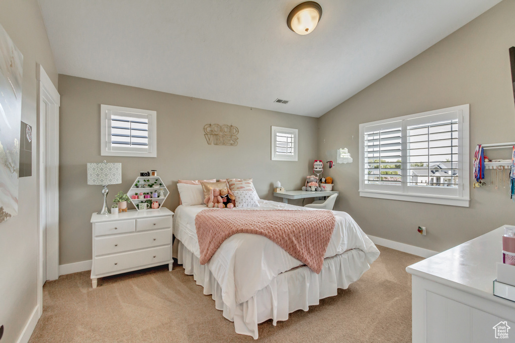 Bedroom featuring lofted ceiling and light colored carpet