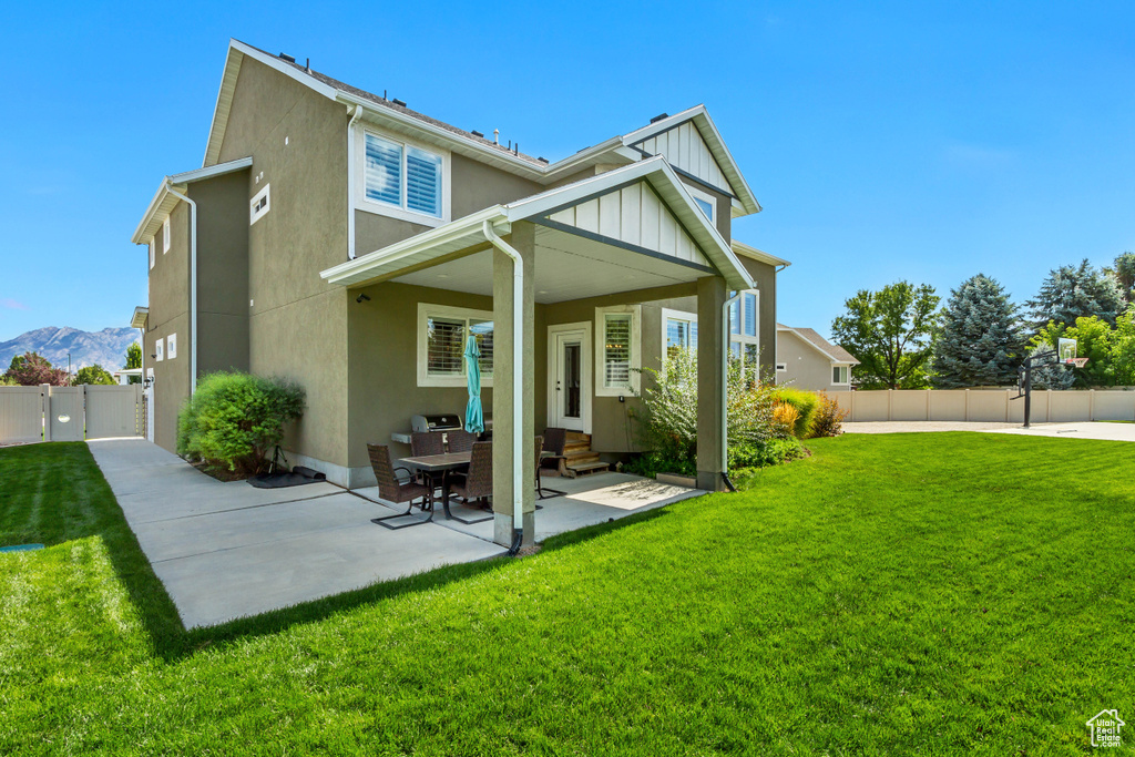 Back of property featuring a yard, a patio, and a mountain view