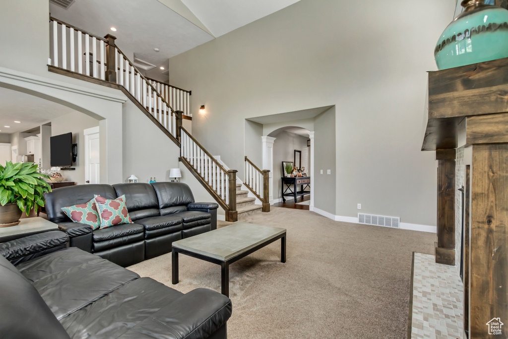 Living room featuring a high ceiling and carpet flooring