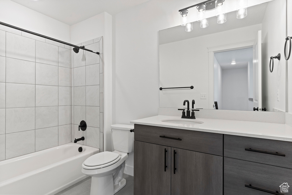 Full bathroom featuring tiled shower / bath, vanity, and toilet