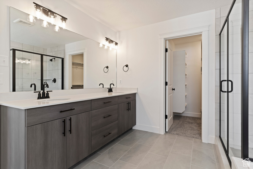 Bathroom with tile patterned flooring, vanity, and a shower with shower door