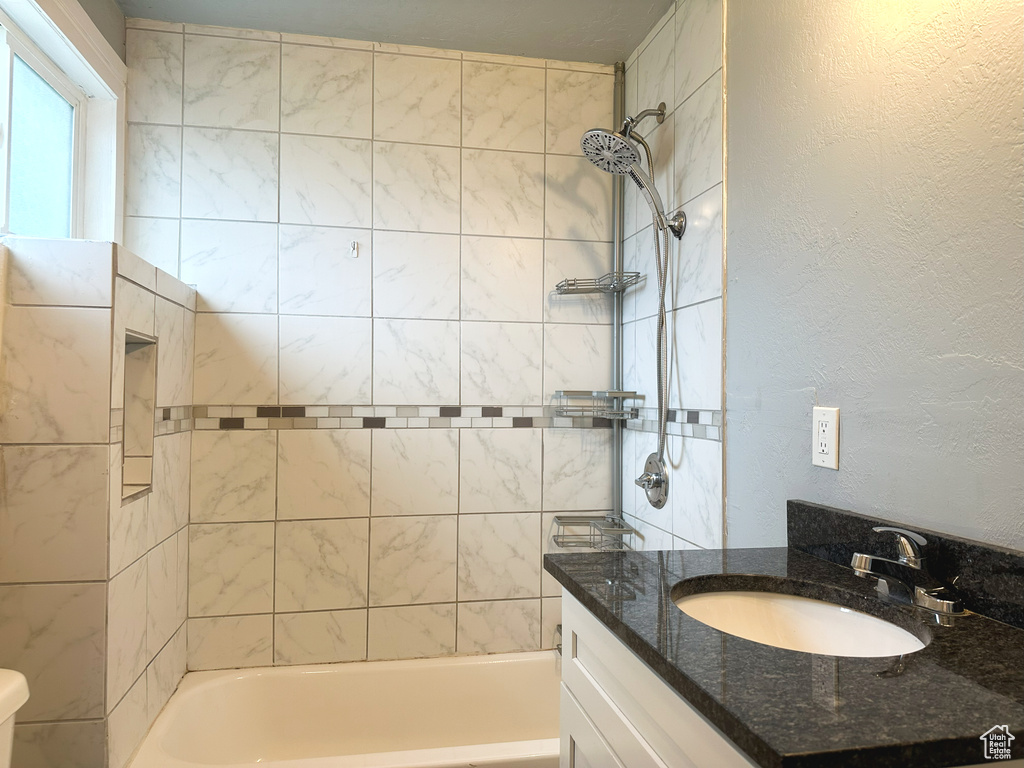 Full bathroom with vanity, toilet, and tiled shower / bath combo