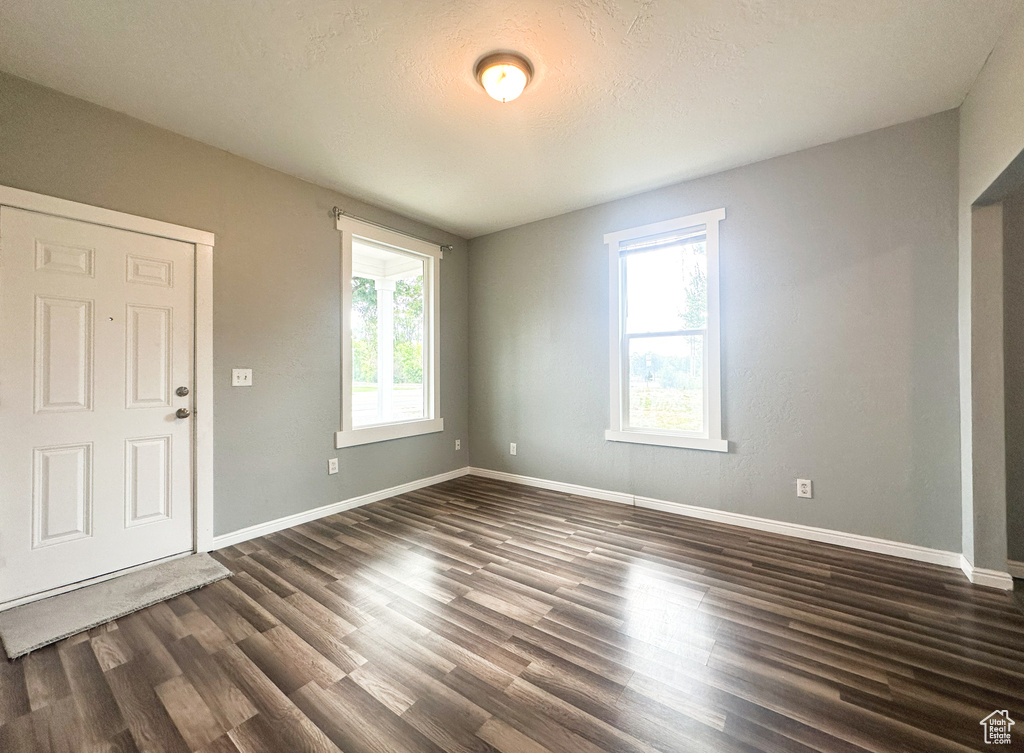 Spare room featuring dark hardwood / wood-style flooring and a textured ceiling