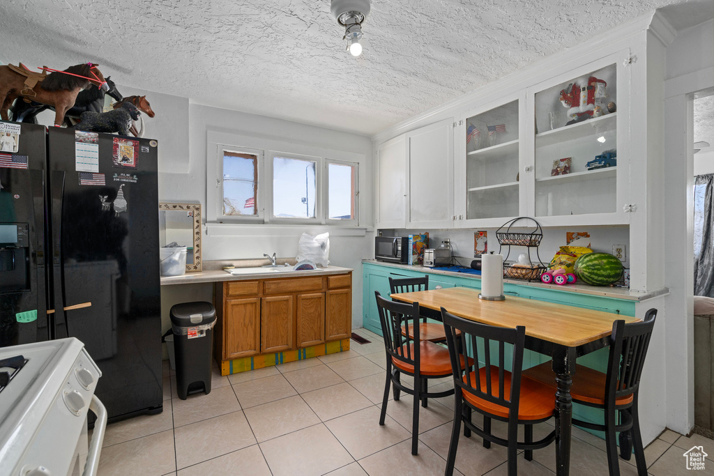 Kitchen with black appliances, sink, and a textured ceiling