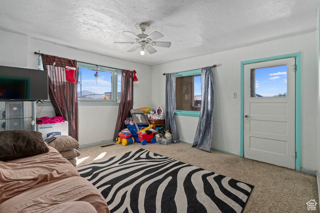 Interior space with a textured ceiling and ceiling fan