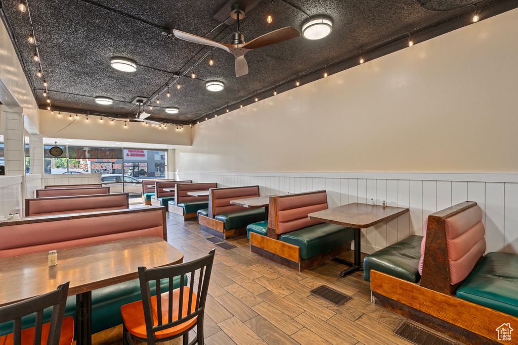 Dining area with rail lighting, ceiling fan, and hardwood / wood-style floors