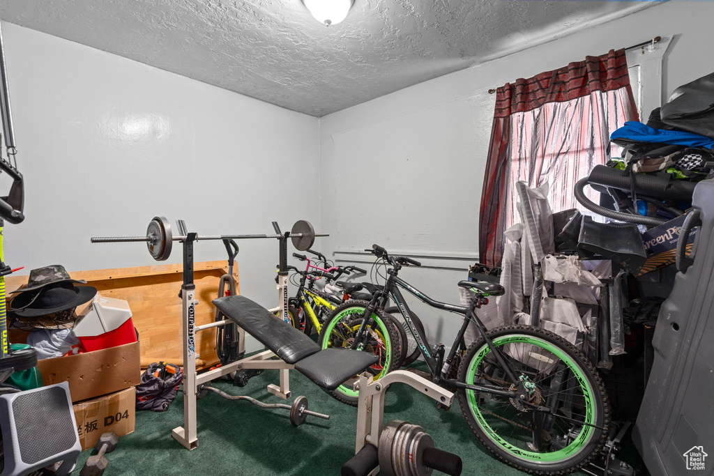 Exercise room with carpet floors and a textured ceiling