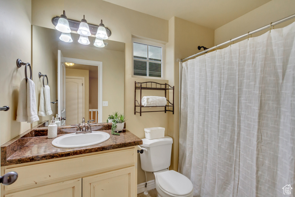 Bathroom featuring walk in shower, toilet, and vanity