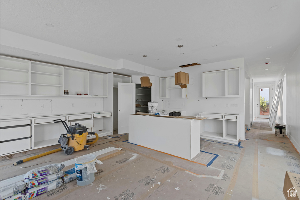 Kitchen featuring a kitchen island and white cabinetry