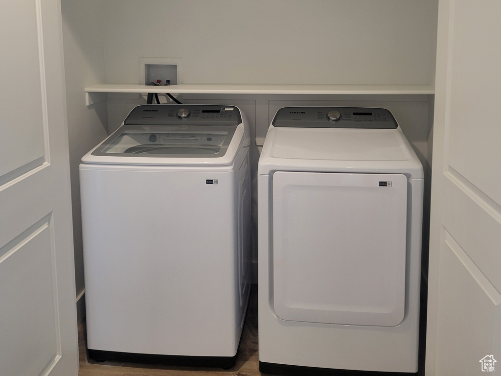 Washroom featuring laundry area, wood finished floors, and washer and dryer