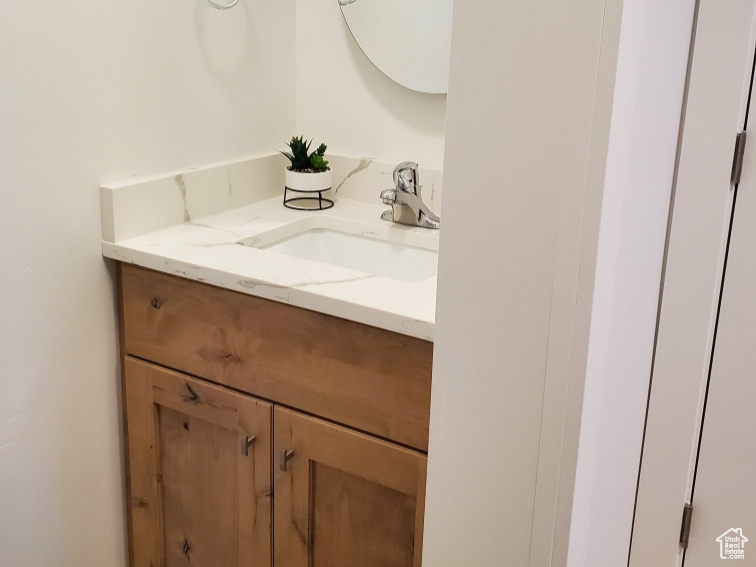 Bathroom with vanity, baseboards, and wood finished floors