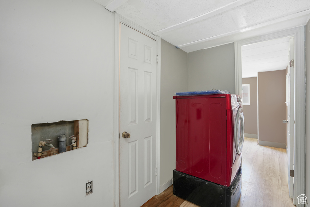 Laundry area with independent washer and dryer and hardwood / wood-style flooring