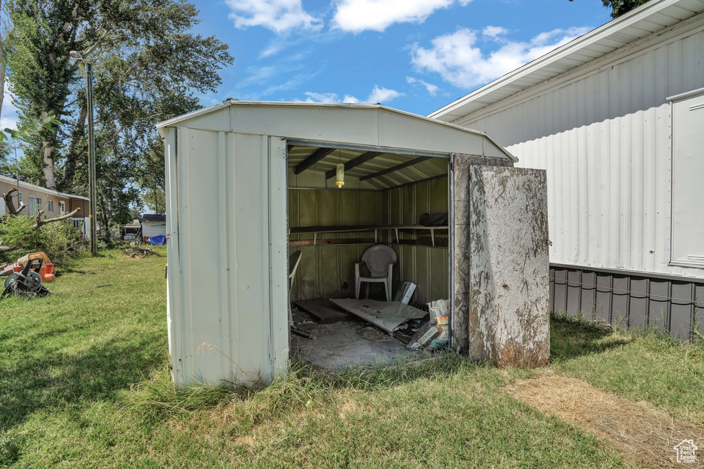 View of outdoor structure featuring a lawn