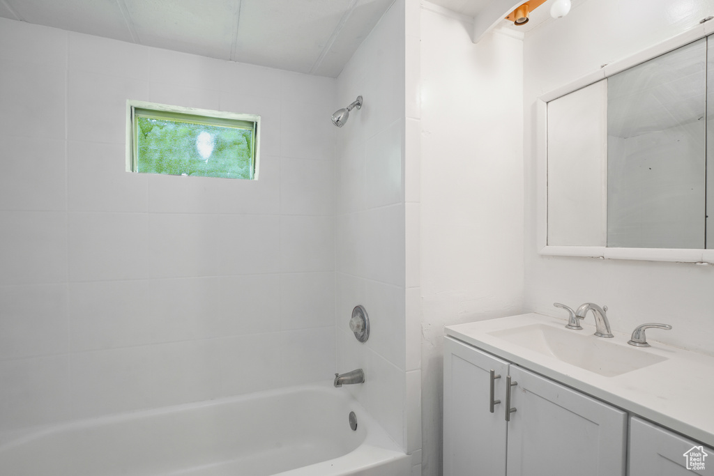 Bathroom with tiled shower / bath combo and vanity