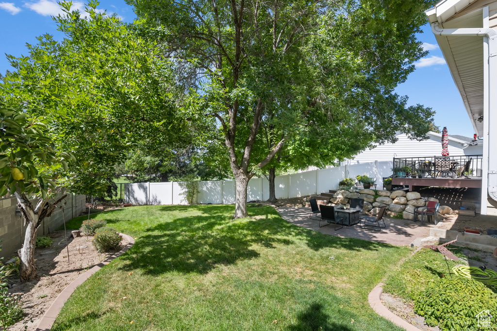 View of yard with a wooden deck and a patio area