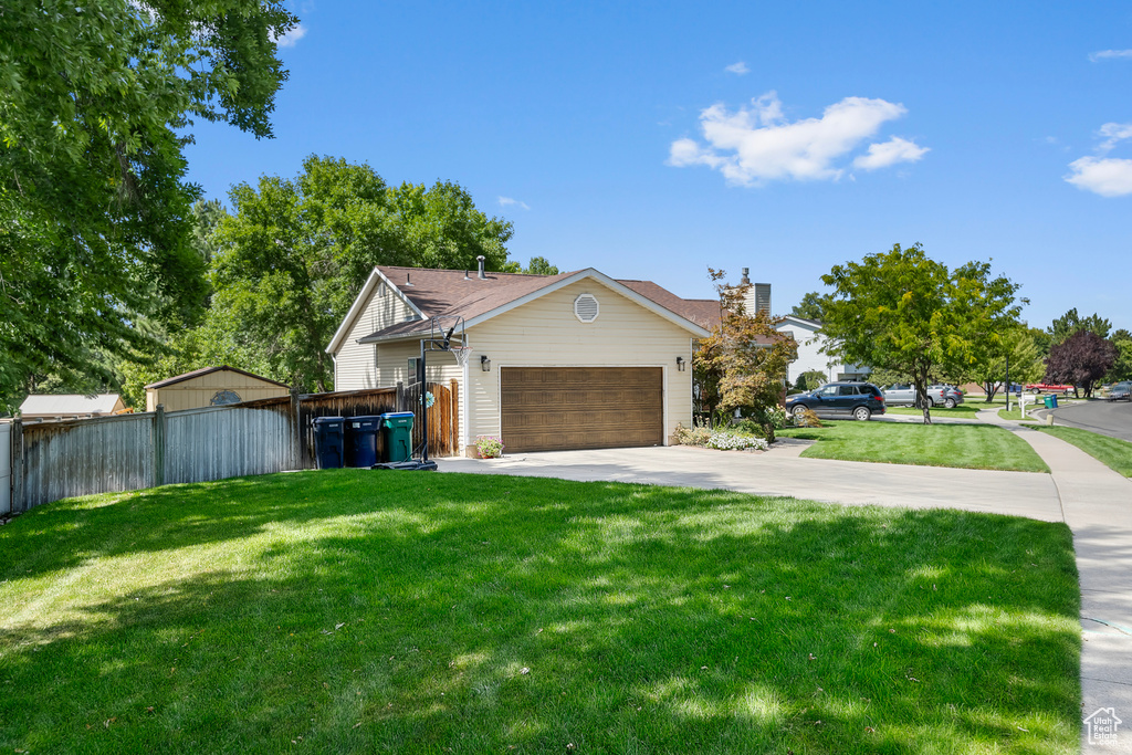 View of front of property featuring a front lawn and a garage