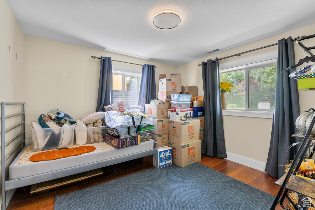 Bedroom with multiple windows and hardwood / wood-style flooring