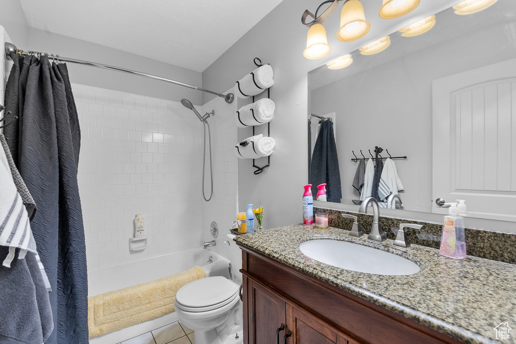 Full bathroom with vanity, toilet, tile patterned floors, and shower / bath combination with curtain