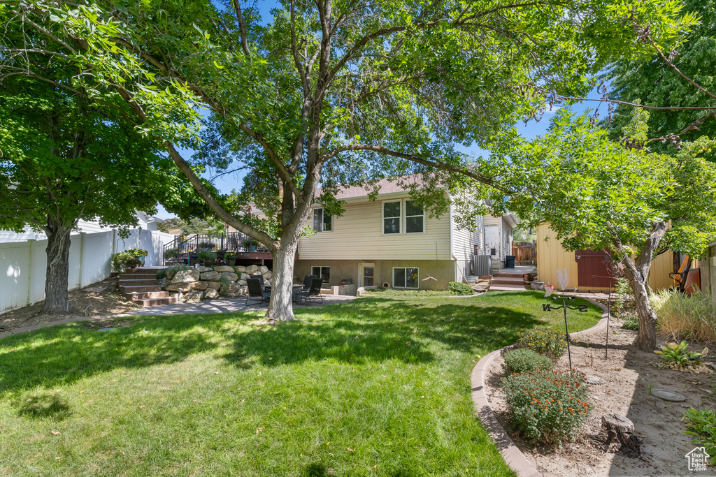 View of yard featuring a storage shed and a patio area