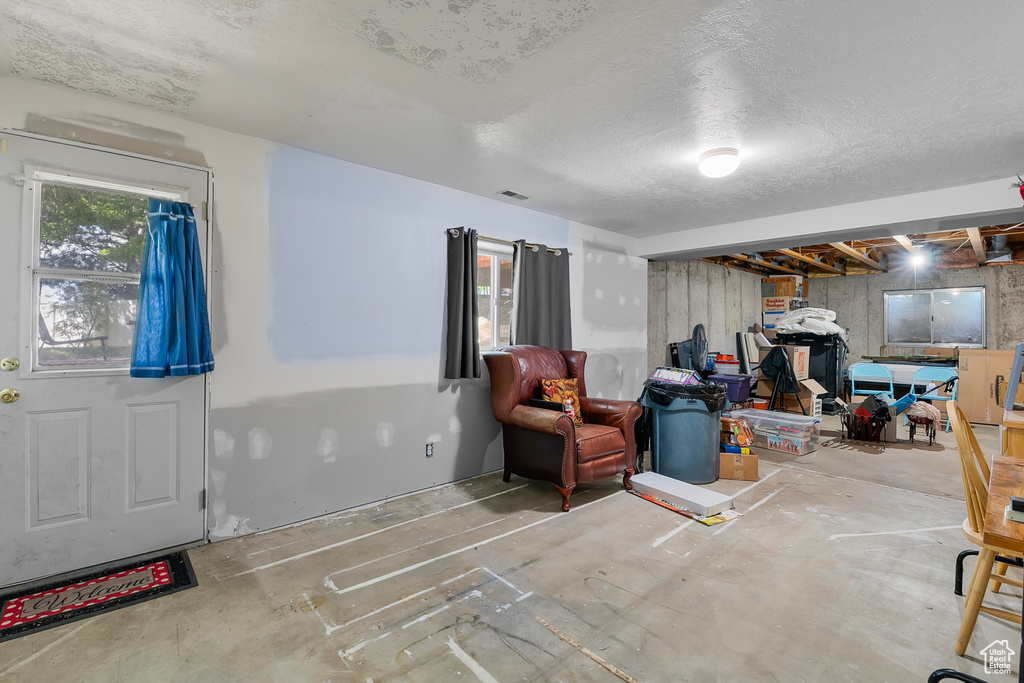 Interior space featuring a textured ceiling and concrete flooring