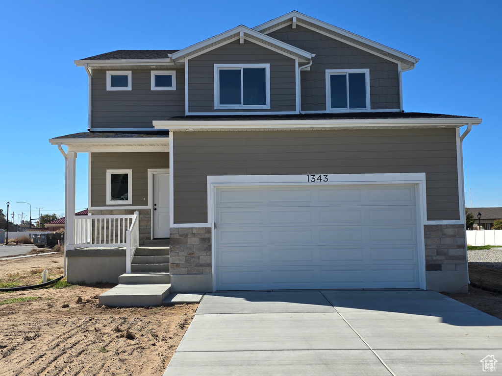 View of front of house featuring covered porch and a garage