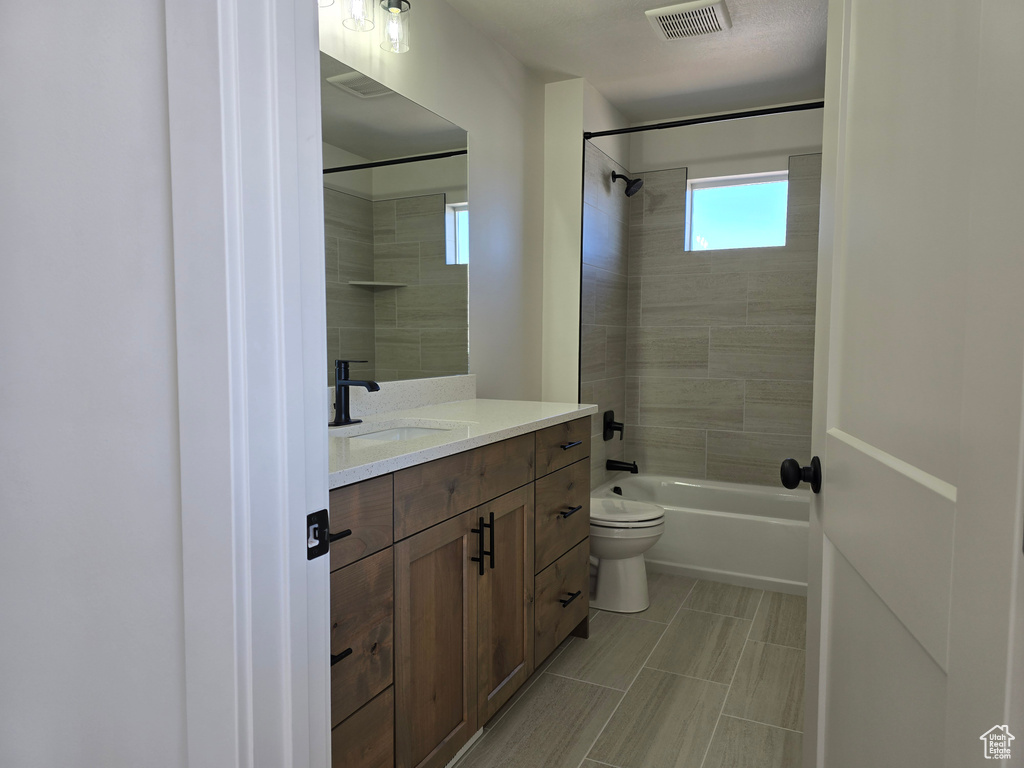 Full bathroom featuring vanity, toilet, and tiled shower / bath